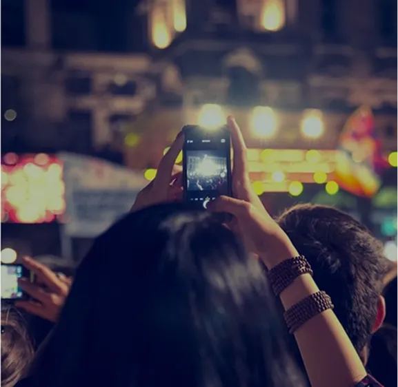A person films an event, representing community gatherings found on an Asian directory.
